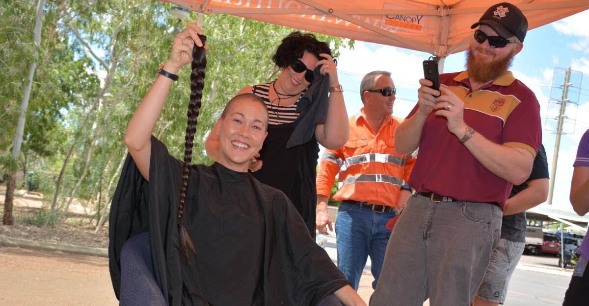 MUCH LIGHTER: Cordelia Chin holds her ponytail to be donated to Wigs for Kids while Larns Puttock and Matt Breen look on. Photo: Chris Burns. 