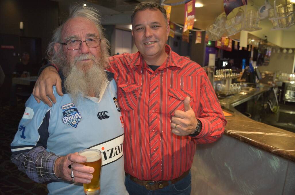 GOOD NATURED SUPPORTERS : Blues supporter Hag Harrison and Maroons supporter Zane King enjoy watching the Origin game at the Buffs Club. Photo: Chris Burns. 