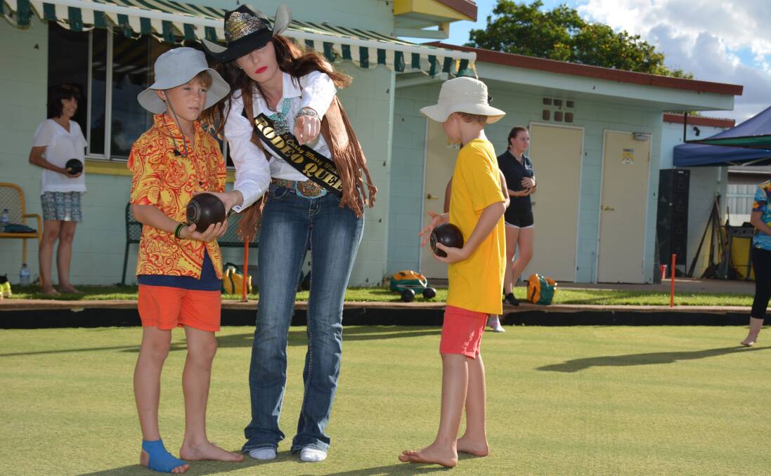 FOCUSED: Cade Ferguson learns lawn bowling from Miss Rodeo Australia contestant Kate Taylor during her fundraising event. Photo: Chris Burns. 