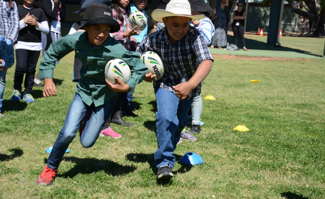 Central State School students Marino Faulkner, Year 4, and Reace Bartley, Year 3, enjoy the NRL clinic at the school. 