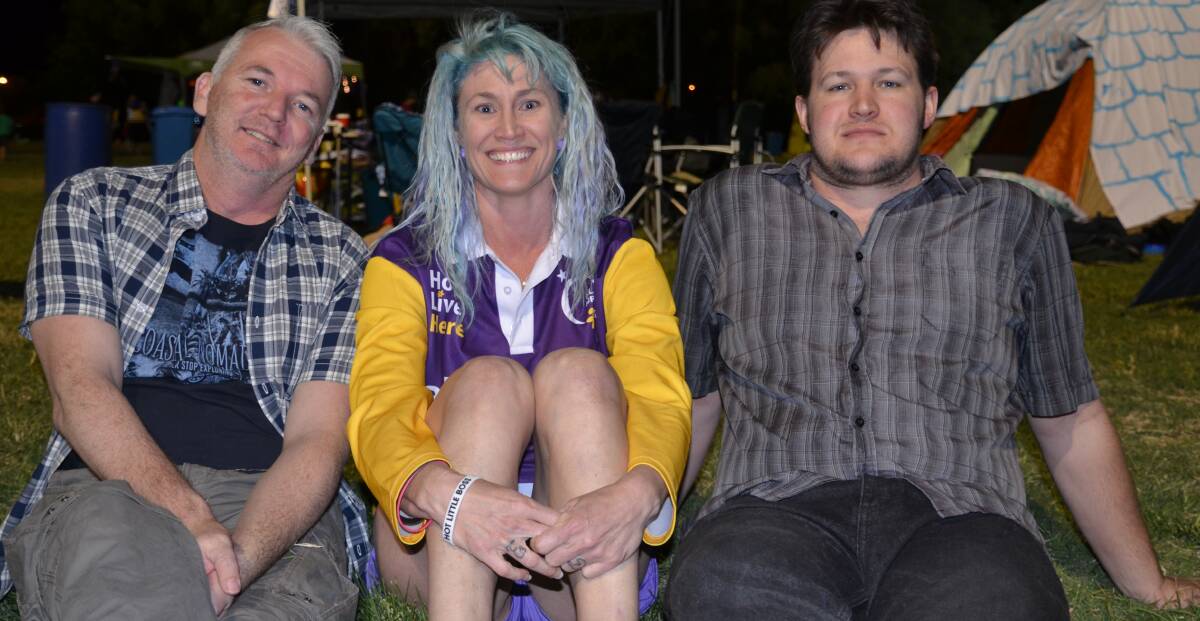 Chris Graham, Susan "Sparkles" Cernoia, and Jonathan Ventura stay up late to watch the bands play on the stage.