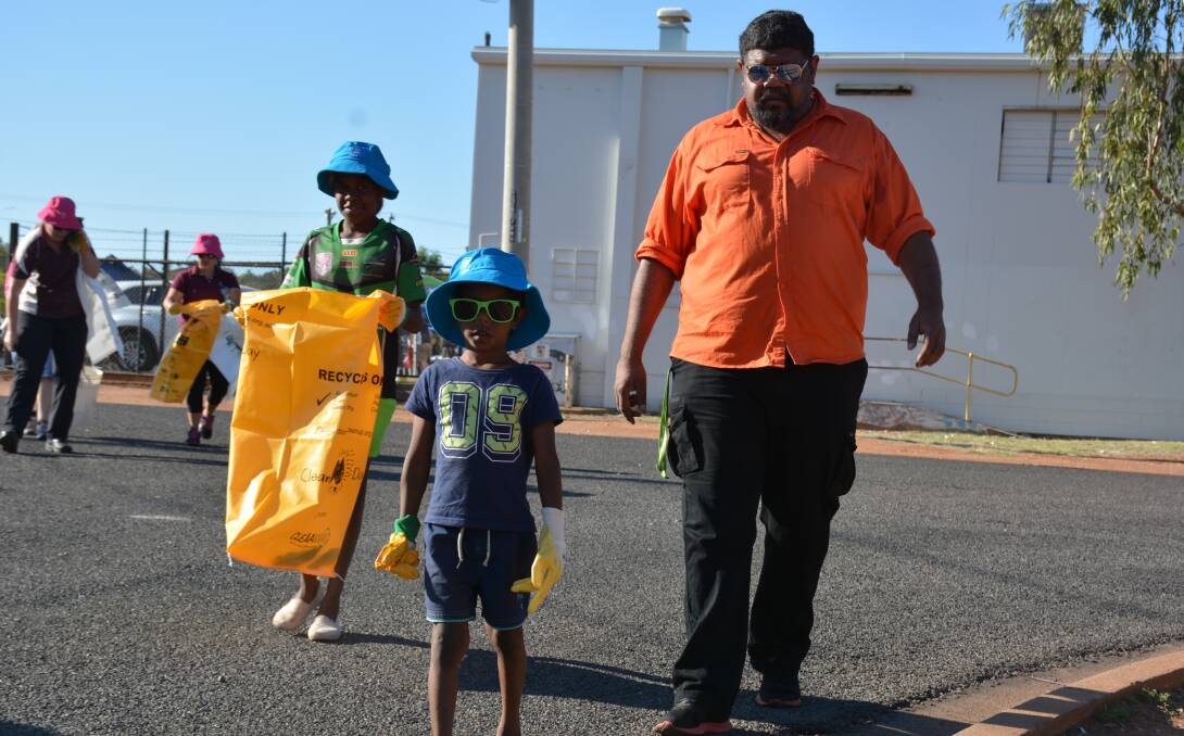   CLEAN UP MARCH: Kasmira King, 11, Benji King, 5, and Chris Doyle walk in Pioneer to search for rubbish to clean. Photo: Chris Burns. 