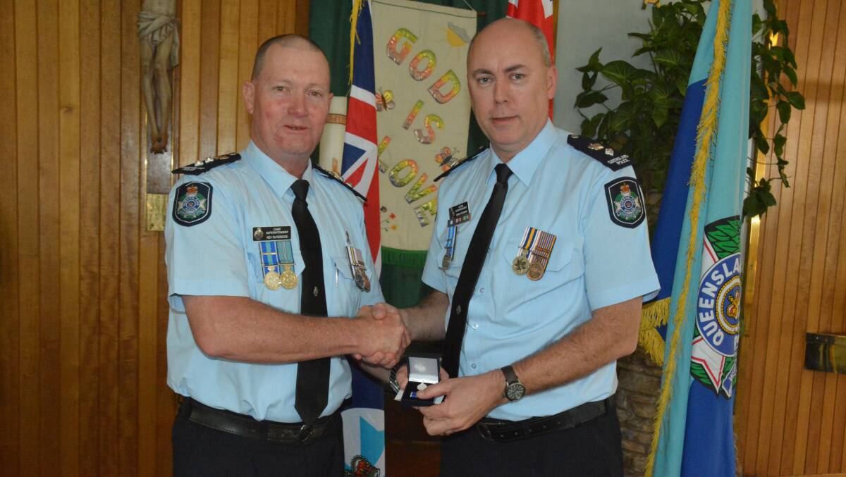 Townsville chief Superintendent Kev Guteridge presents acting Mount Isa Superintendent Chris Hodgman with his 30 year clasp. Superintendent Guteridge also reached his 30 year milestone this year. 
