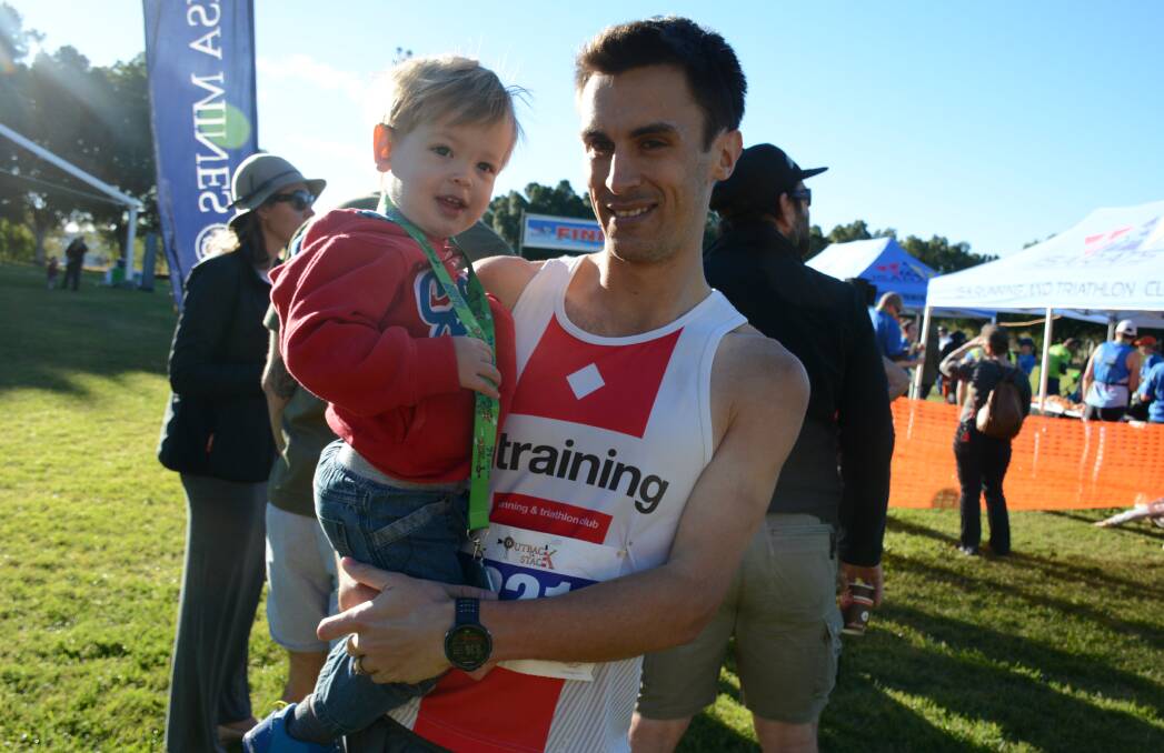 Levi Hobbs, 2, with his father Aidan Hobbs, who endured a head cold yet managed to win the half marathon at Outback to the Stack. 