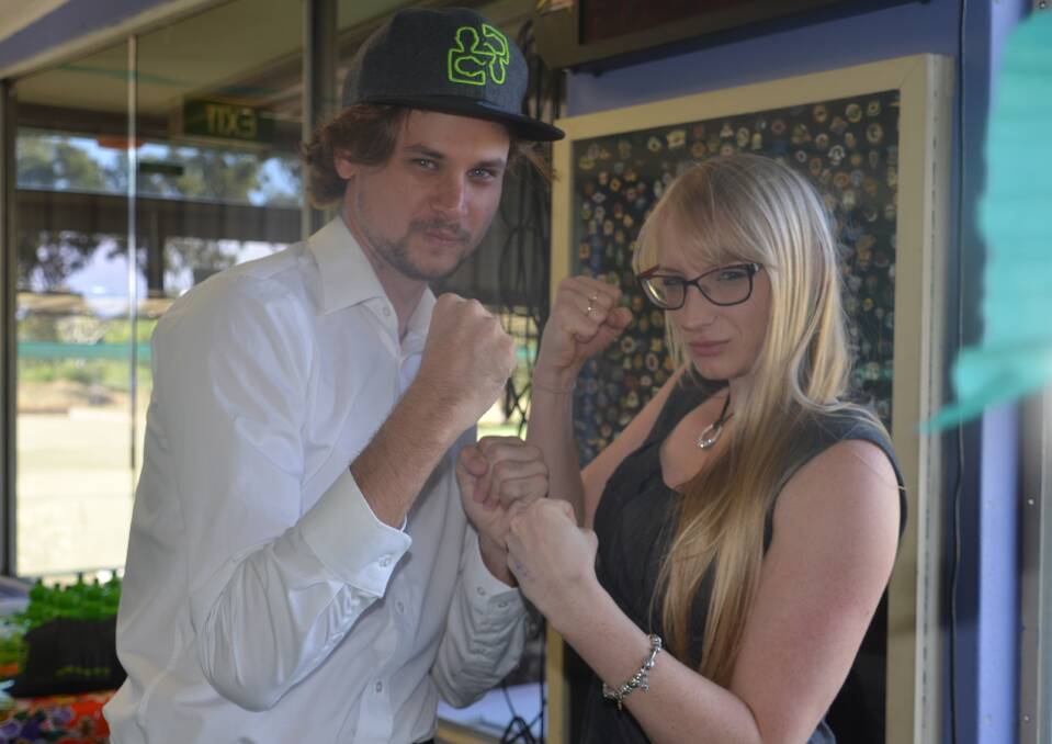 FRIENDLY RIVALRY: North West Star journalist Chris Burns and ABC North West presenter Emma Cillekens pose for a "media battle" photo before they argue against each other over whether or not moving to Mount Isa was the best decision they made. Photo: Derek Barry. 