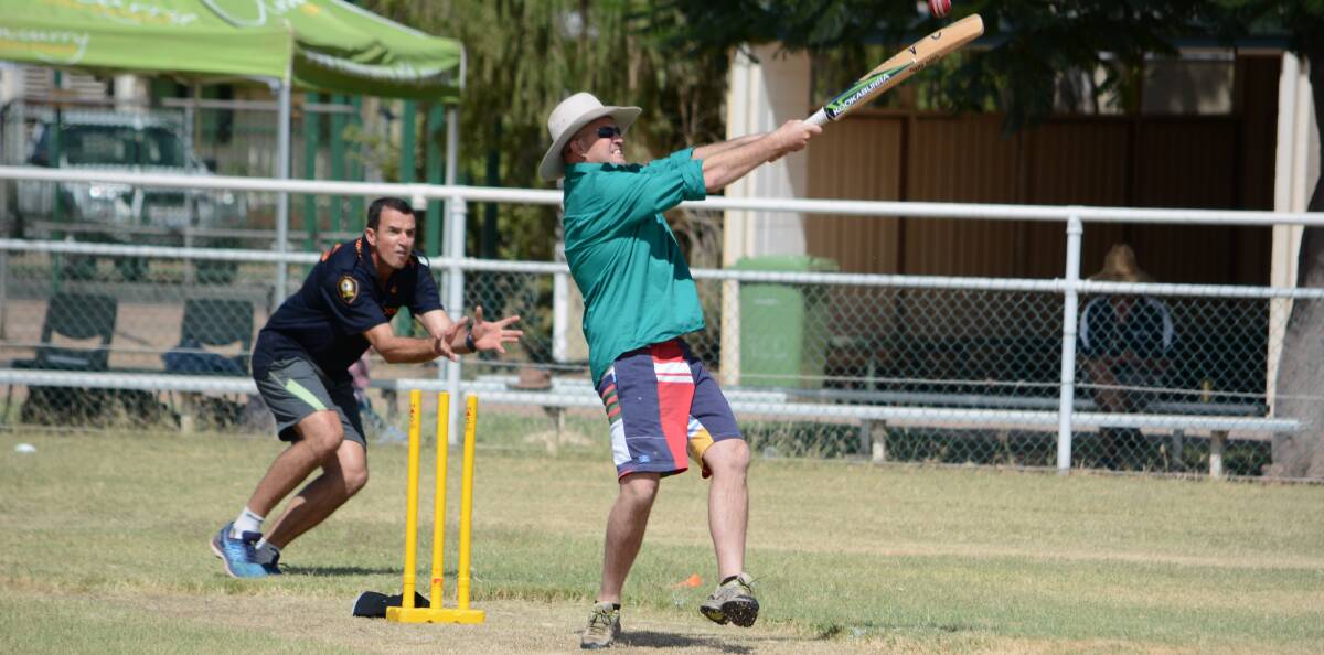 GETTING TENSE: Cloncurry mayor Greg Campbell focuses everything he can in hitting the ball during the competitive match between the council and the emergency services in the eight-a-side match. Photo: Chris Burns. 