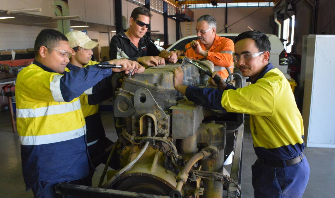 AT WORK: Tafe students Connor Mcleod, Gordon Barry, Popey's owner Adrian Pope, Tafe teacher Zane King and student Adam Kolody work on the engine.  Photo: Chris Burns