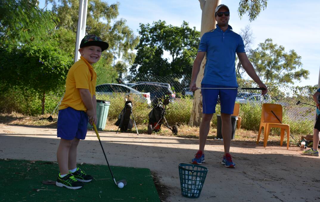SUNDAY GOLF: Harry Horrobin, 5, is taught to swing at the Mount Isa driving range during the recent try-out day. His instructor is Brad Thompson. Photo: Chris Burns. 