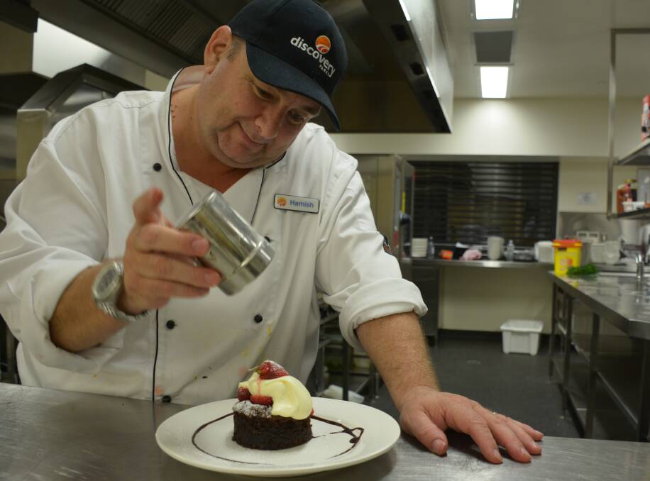 Cloncurry Discovery Parks operations manager Hamish Griffin prepares a dessert during a dinner. Two federal ministers attended the dinner last Thursday.