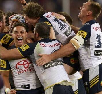 Overcome: The Cowboys players celebrating their victory at the grand final in a close 17-16 over the Broncos. 