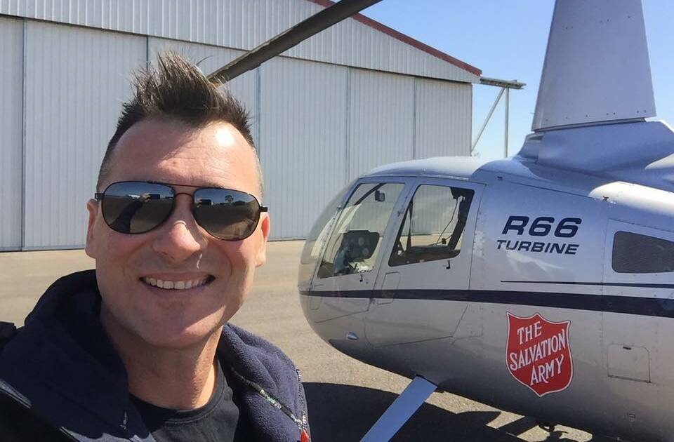 Adam Brand pictured with the Salvation Army helicopter in Mount Isa. Photo: Facebook. 