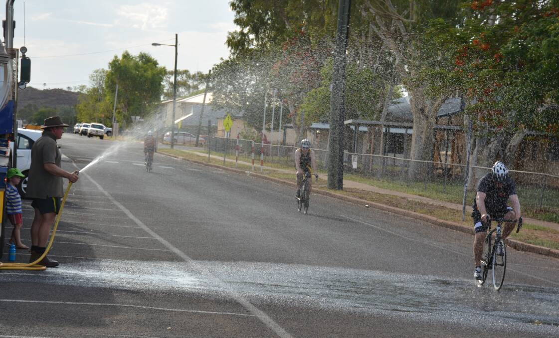 Cyclists are hosed to help cool them in the 42 degree heat. 