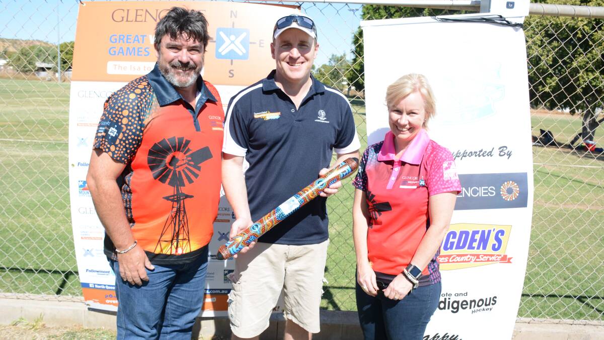 Great Western Games' ambassador Jon Sieben with Glencore's chief mining officer of copper assets, Matt O'Neill, who holds the game's message stick, and Cr Peta MacRae. They attend the junior hockey presentation in Mount Isa. Photo: Chris Burns. 
