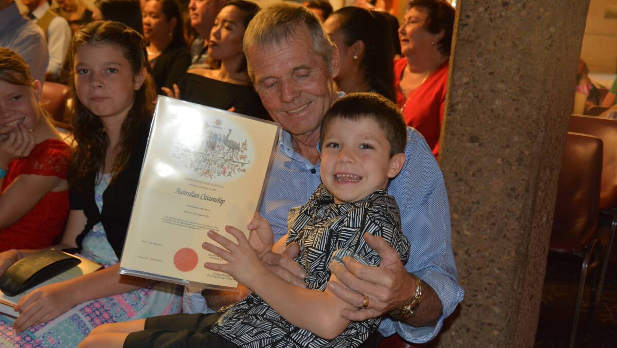SPECIAL MOMENT: David Beattie, formerly a citizen of Northern Ireland, lets his grandson Kadyn, 6, hold his new Australian citizenship certificate during the ceremony. Photo: Chris Burns. 