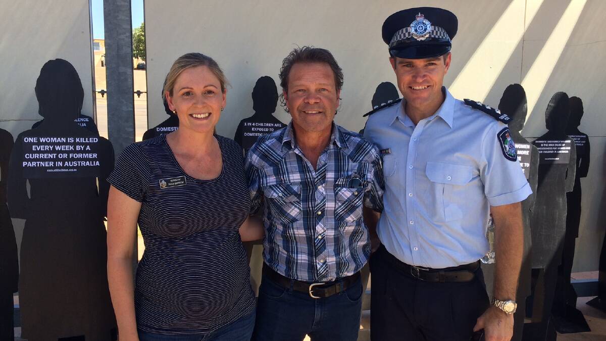 RAISING AWARENESS: Sergeant Paige Barrow, Troy Cassar-Daley and Acting Inspector Neil King in front of an installation highlighting White Ribbon. Photo: QPS. 