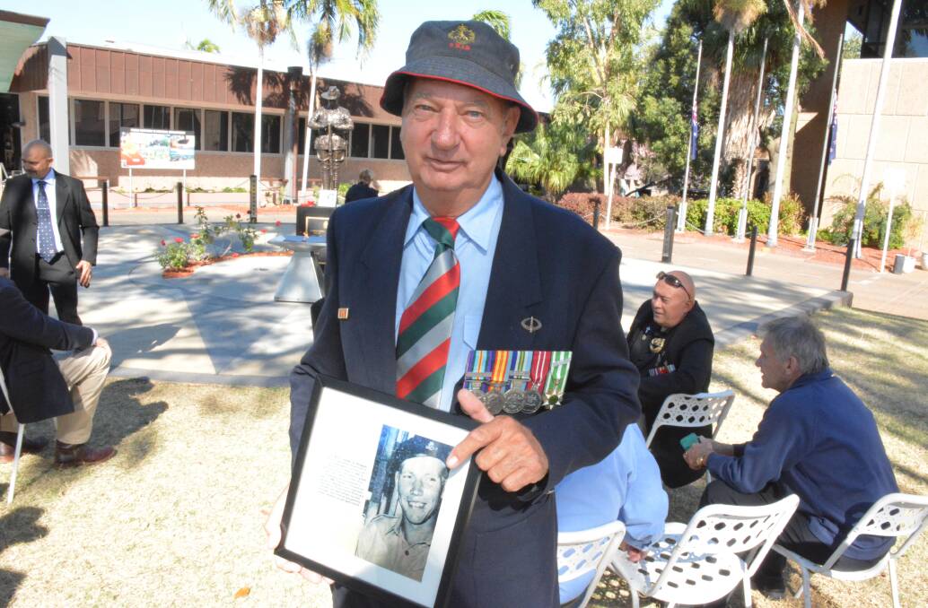 IN TRIBUTE: Vietnam Veteran John 'Speedy' Toonen holds a framed picture of fallen comrade Timo Pesonen, who is buried in the Mount Isa graveyard. Photo: Chris Burns. 
