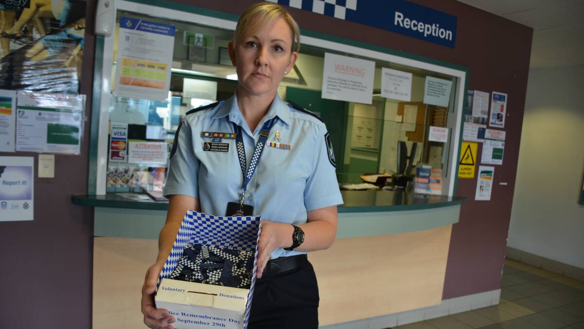 Mount Isa Police Station's officer-in-charge, Snr Sgt Renee Hanrahan, with police badges that can be bought to support Queensland Police Legacy. Photo: Chris Burns. 