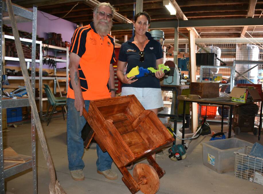 SHARING: Mount Isa Men's Shed coordinator Richard Lane gives created items to Breast Friends Day volunteer Susan Dowling for fundraising. Photo: Chris Burns. 
