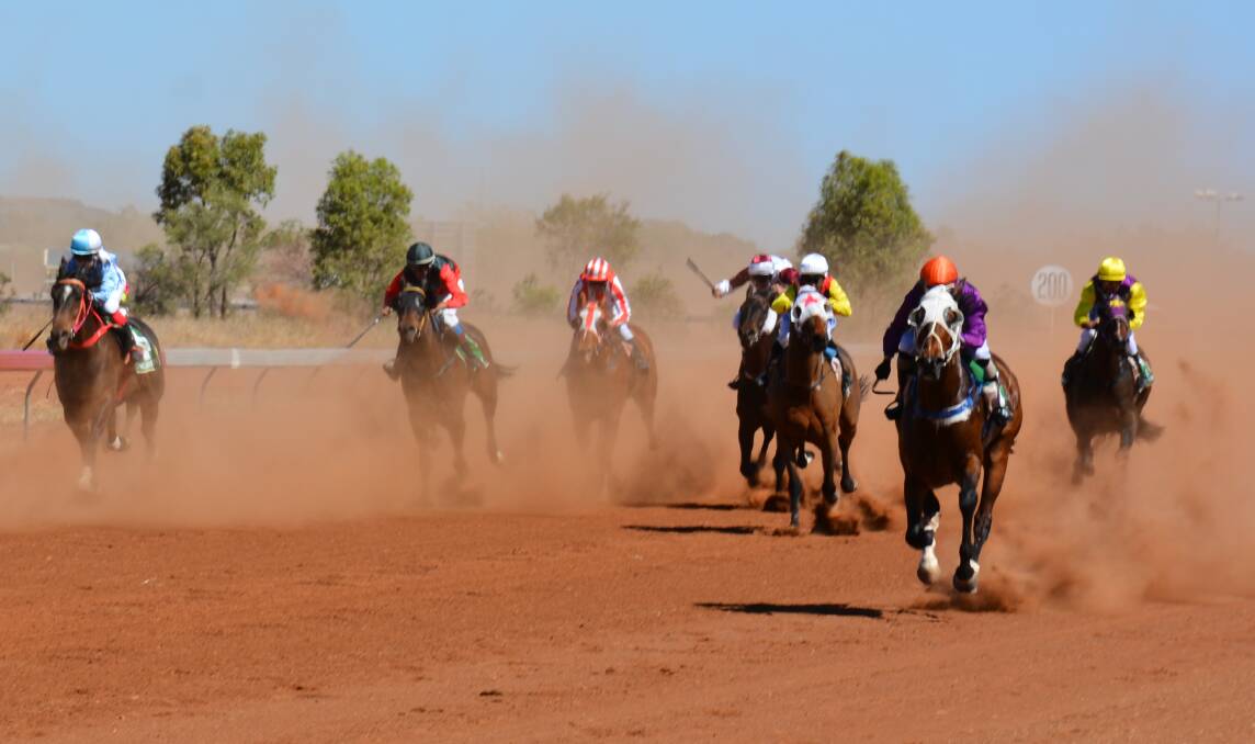 DUST RISES: Racehorses ride furiously in a previous spring races meeting held at Cloncurry's Schumacher Park. Photo: Chris Burns. 