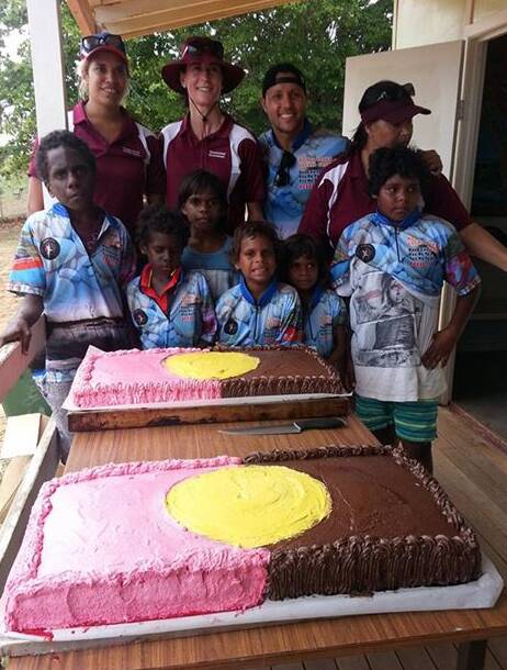 Flag feast: Scott Prince (back, second right) helps commemorate Memorial Day on Mornington Island with two giant cakes baked locally to feed 1000 mouths. Photo: contributed.