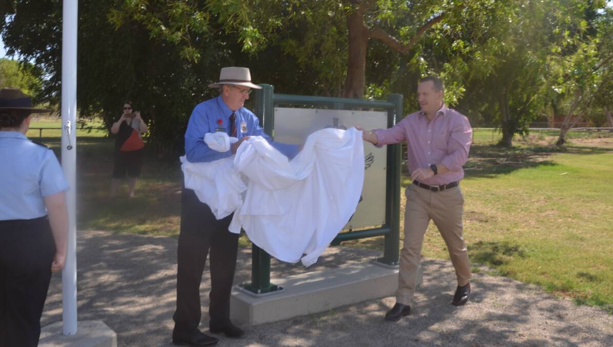 Returned serviceman, Stephen Carrington, and Mount Isa Mines CEO, Matt O'Neill, unveil the three new metal signs.