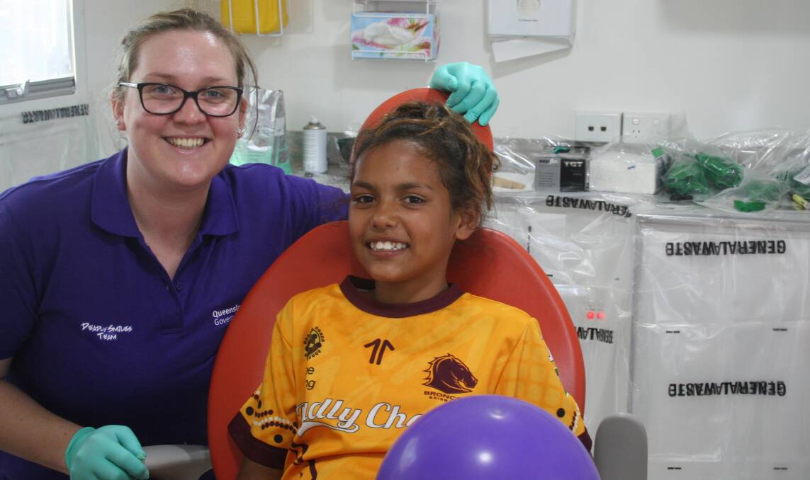 DEADLY SMILES: NWHHS dentist Alison Walker with Ceara Doomadgee inside the Gidgee Healing Dental Van at a 2016 Deadly Smiles event at Krutschnitt Oval with the Oral Health team. Photo: supplied