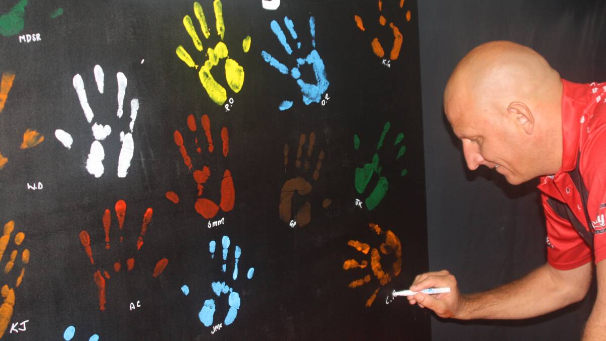 Men signed their own painted handprints. Photo: Esther MacIntyre 