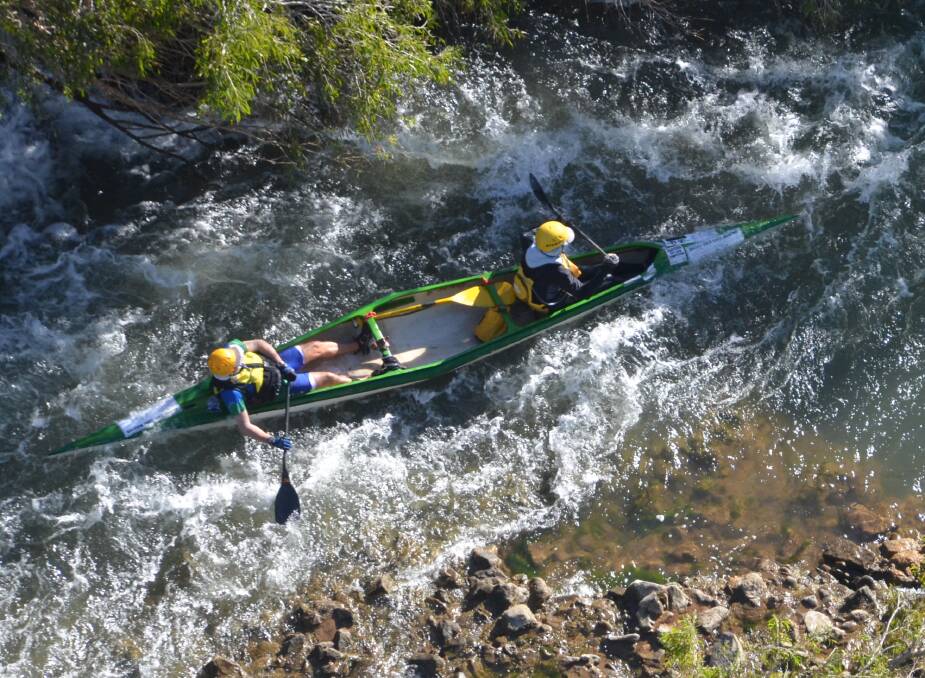 RAPIDS AND ROCKS: A lucky view of a two-person canoe making its way through the rapids of the Gregory, as seen from a mustering helicopter. Photo: Esther MacIntyre