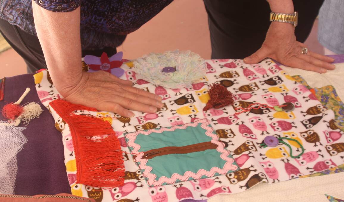 Fidget blankets are made by sewing sensory play objects (zips, buttons, pockets, ribbons) to lap blankets, and provide sensory and tactile stimulation for the restless or "fidgety" hands of someone with Alzheimer's or dementia.
