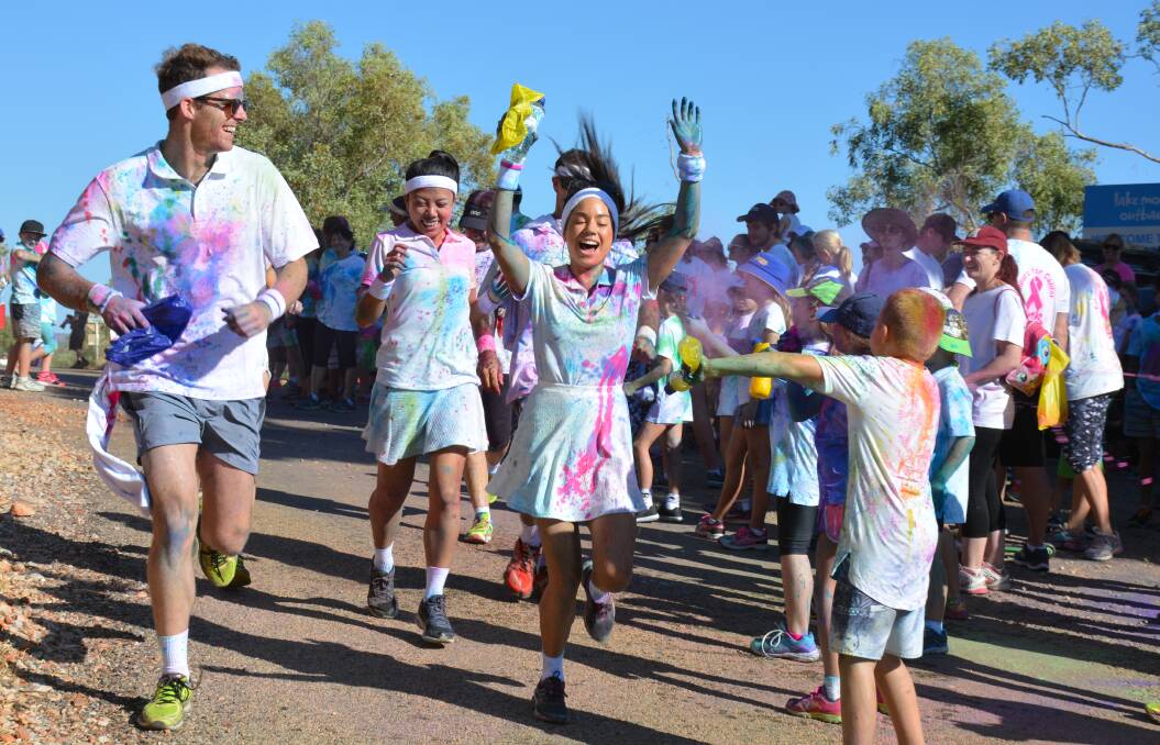 HANDS UP: James Dudley and Karina O'Loughlan can't dodge the paint shooters at Colours For Cancer 2016. Photo: Chris Burns