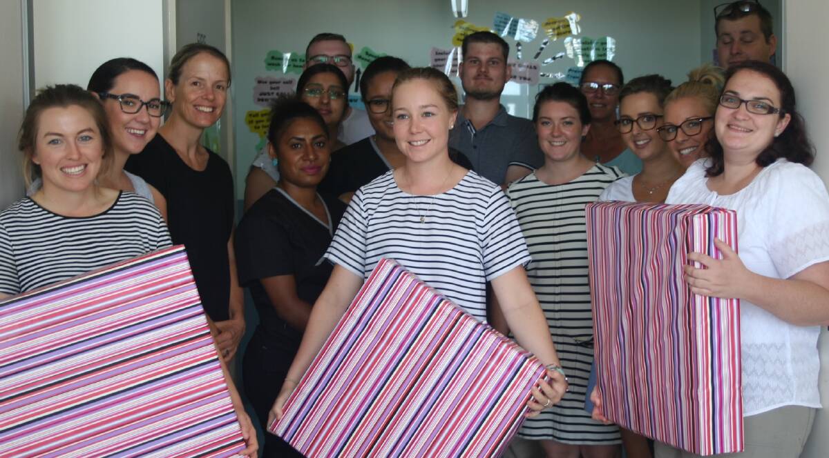 FIRST YEARS: Some first year practitioners with their presents – parcels of their uniforms, wrapped up for them. Jordan Gilligan from Cunnamulla, Chazlyn Morrissey from Cloncurry, and Amelia Rogers from Brisbane, with their fellow newbies in the background. Photo: supplied.