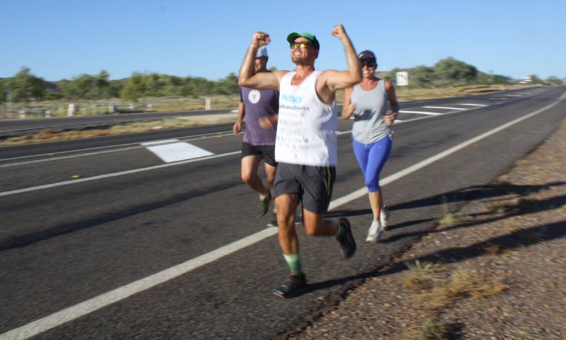 GC TO ISA: Flanked by Robbie Katter and Coz Thompson for the last 3km into town, Doug Black arrives in Mount Isa on foot after three weeks and 1800km through the desert. Photo: Esther MacIntyre