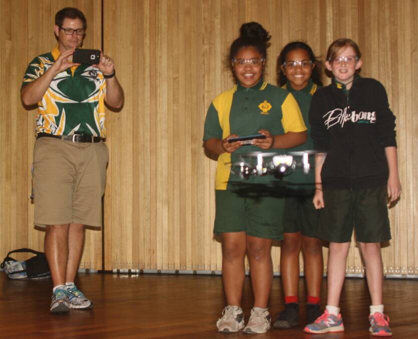 SHE FLIES: Healy State School Principal, David Hardy, and students Tuiai Koukou (10), Nicole Griffin (10), and Kady Cheshire (10) learn how to fly a drone using a tablet. Photo: Esther MacIntyre 