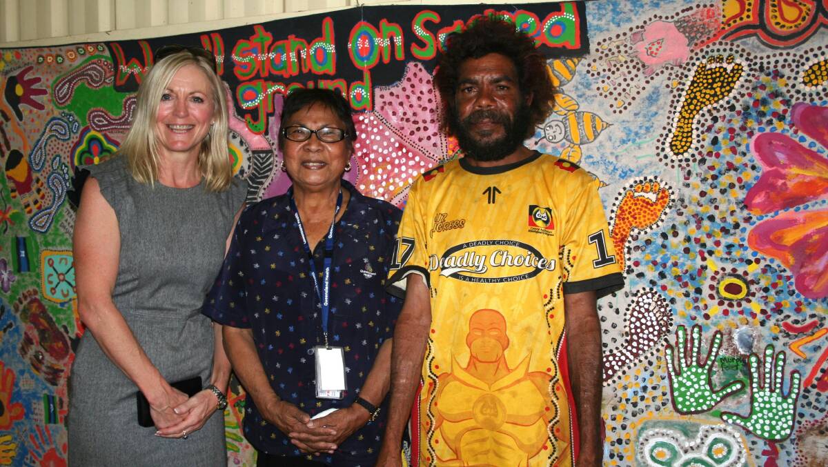 NWHHS CE Lisa Davies Jones, Aunty Fran Page, Terrence McMillan with the art work banner created by clients of the Burke Street Shed. Photo: supplied
