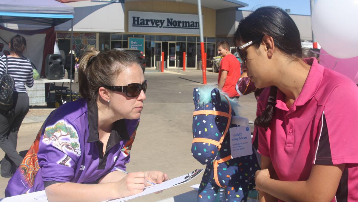 WINTER WELLNESS: A health worker signs up parents for Gidgee Healing's numerous health services in Mount Isa. Photo: Esther MacIntyre