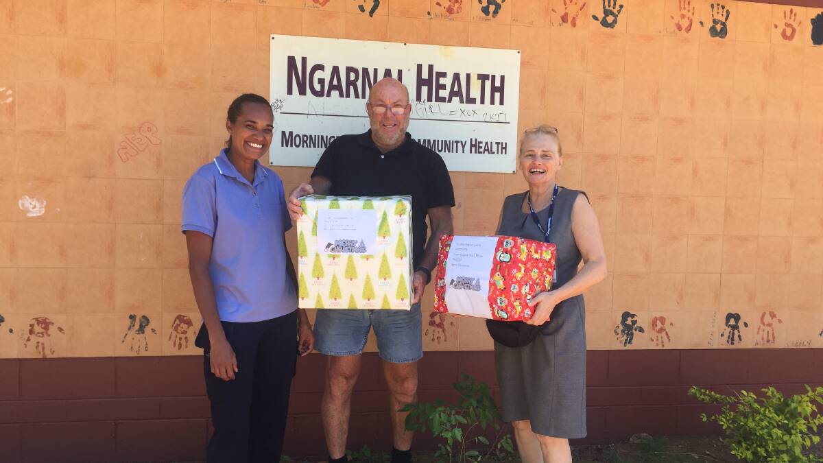 Mount Isa Hospital staff: community health nurse Coreen Reading, Clinical nurse, Micheal Wood and Director of Nursing Heather Byrne, with the new shoes. Photo supplied.