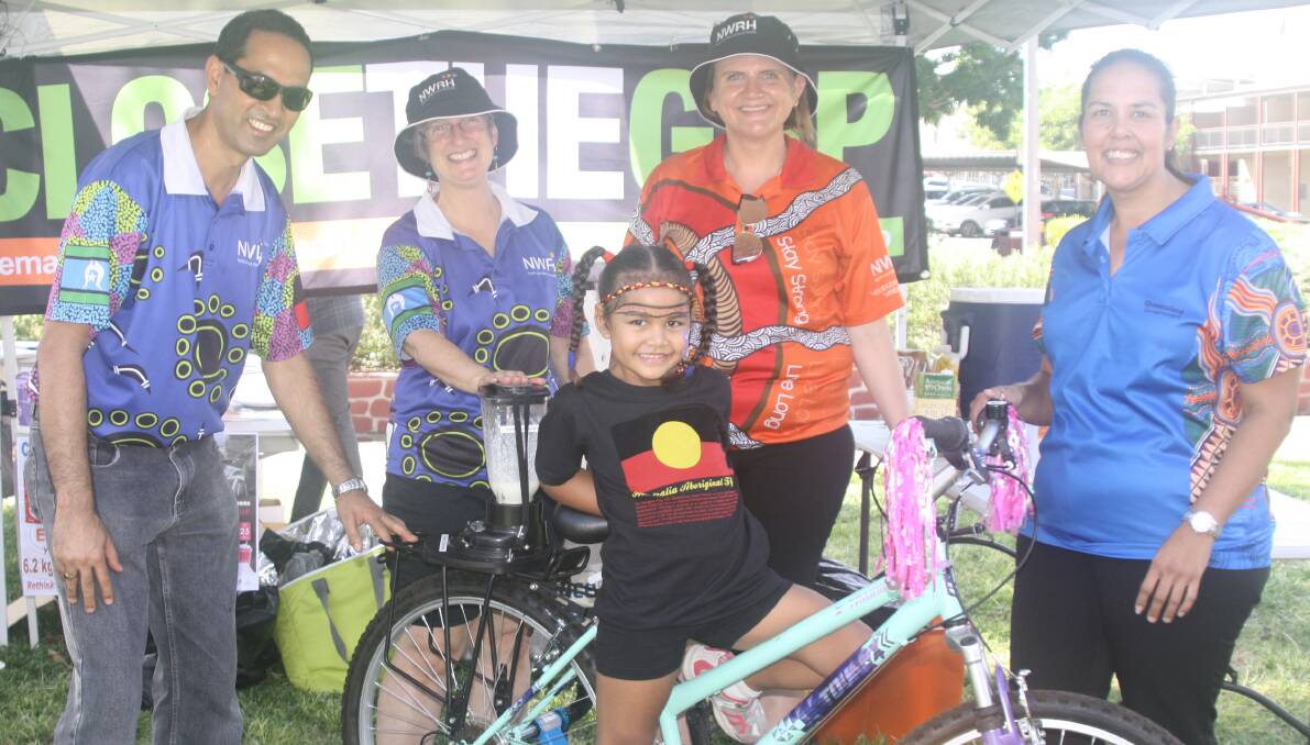 HEALTHY FUN: Maleya Raitava tests a "smoothie bike" at Close the Gap Day with help from NWRH workers Govind Ojha, Lyndell Brown, Stevie Dyer, and mum Christine Mann.