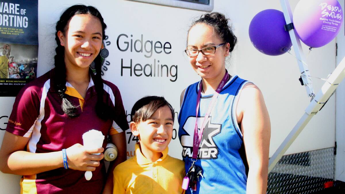 Janelle Wolland-Ropiha (14), Roparti Iasona-Ropiha (7) and mum Maria Ropiha wait outside the Gidgee Healing Dental Van at a Deadly Smiles event in 2016. Photo: supplied
