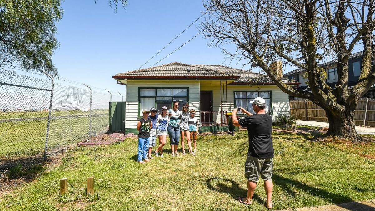 A family have their photo taken in front of the famed house. Photo: Justin McManus

