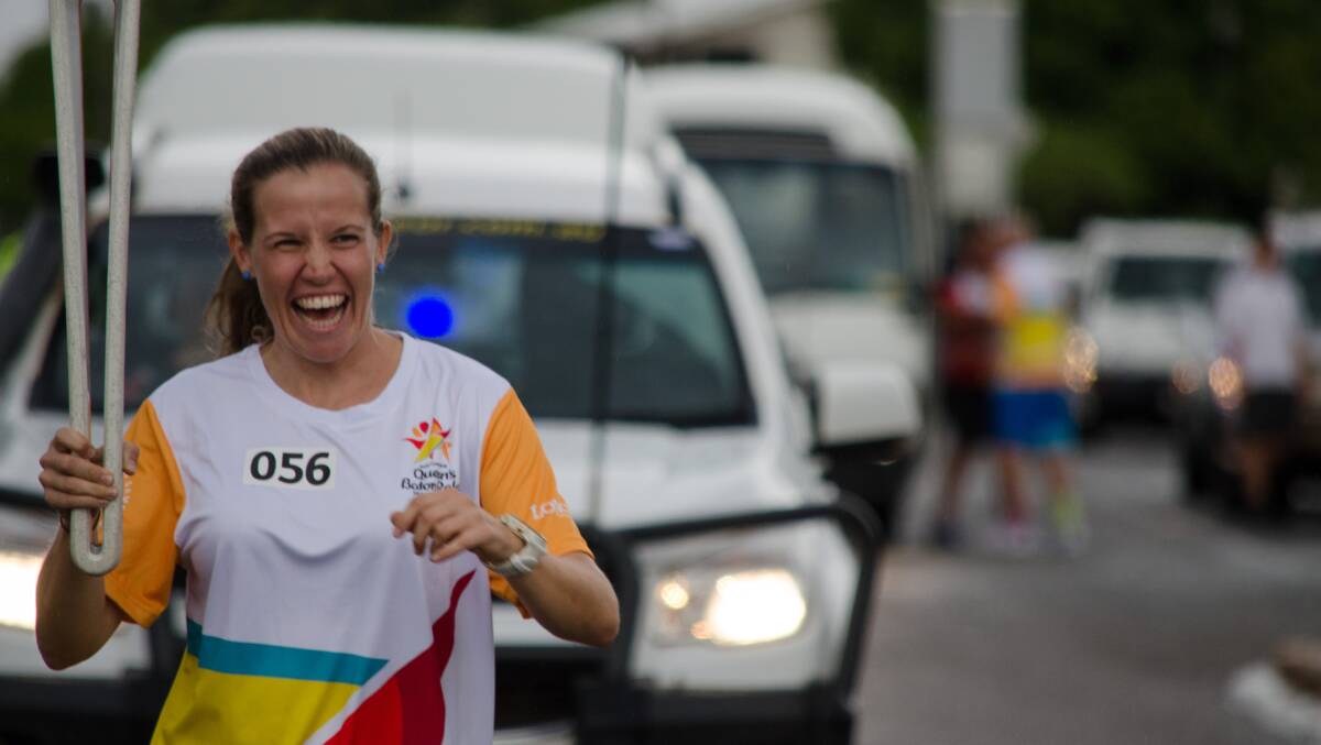 BIG SMILES: Michelle Ball happily runs the distance bearing the baton.
