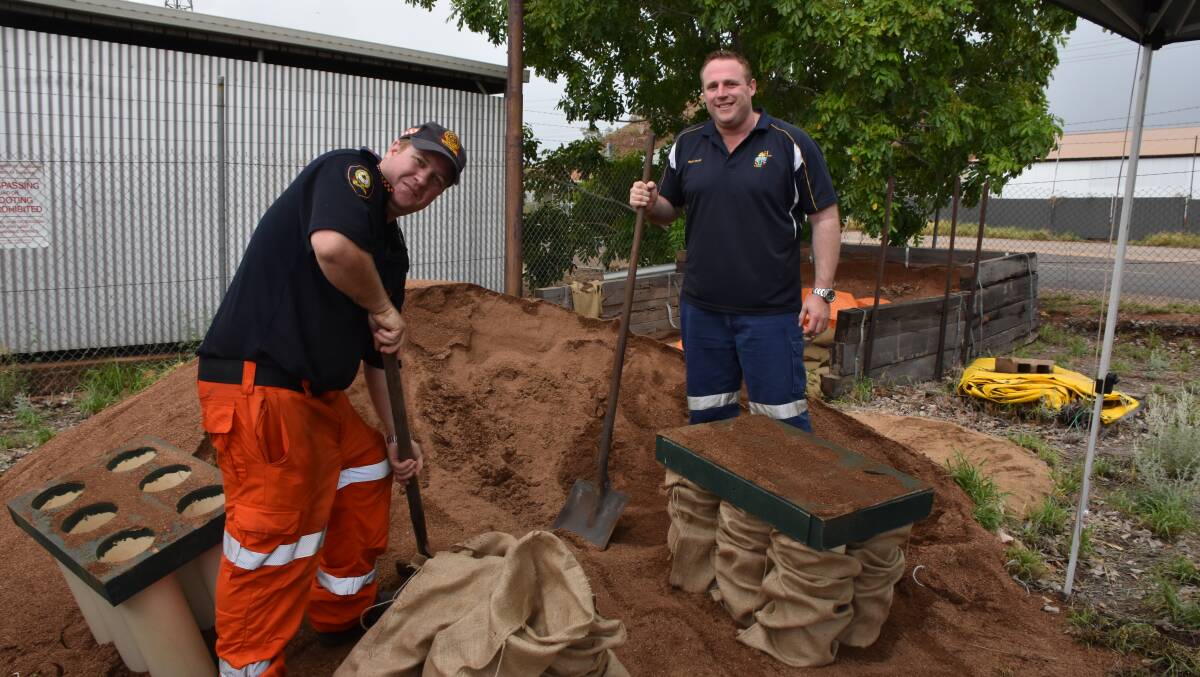 BETTER TO BE PREPARED: SES Deputy Local Controller for Mount Isa David Muston and Wade Krause shovel sand in preparation for impending rainfall. Photo: Melissa North