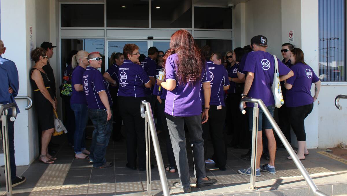 A ban of purple supporters block the entrance to the Mount Isa Court House.