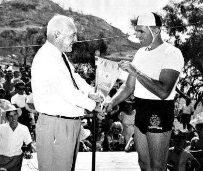 Sir George Fisher was knighted in 1967. Seen here presenting a pennant to Mount Isa lifesaver G. Walsh. 