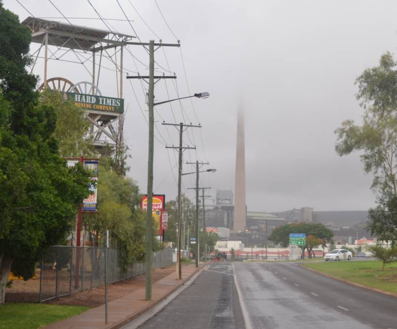CLOUDED IN: The Mount Isa lead stack disappears under the rain on Friday. Forecasters expect more rain this week. Photo: Derek Barry