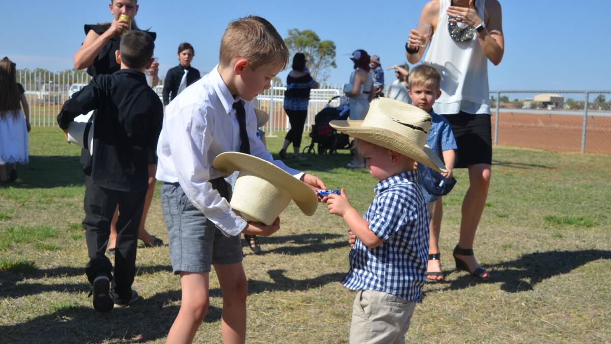 GOOD TURN: One youngster was not quite quick enough on the draw with the lolly drop at the Cloncurry Races but an older boy came to the rescue. Photo: Derek Barry