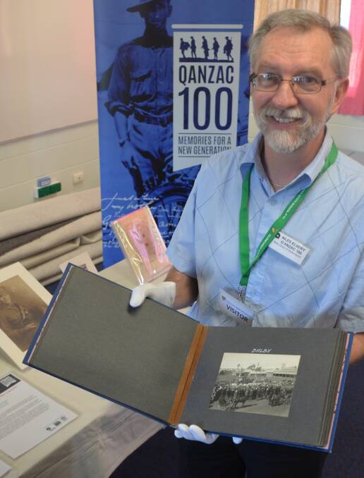 WHITE GLOVES: Niles Elvery with some of the exhibits in the First World War treasures exhibition in Cloncurry this week. Photo: Derek Barry