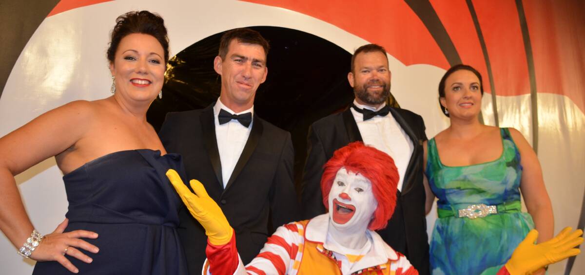 LET'S PARTY: Kim and Shaun Higgs and Matt and Kate Brewster pose for a photo with Ronald McDonald as they enter the charity ball. Photo: Derek Barry.