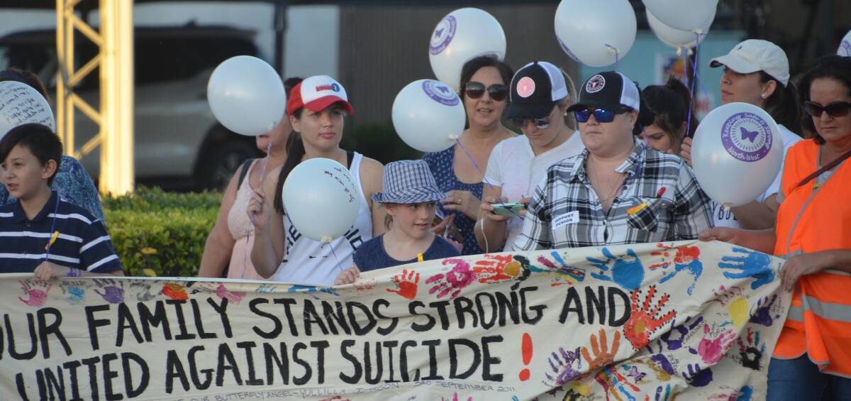 UNITED FRONT: Marchers against suicide in Mount Isa walk down Rodeo Drive on Thursday. Photo: Derek Barry