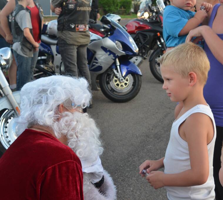 JUST BECLAUS: Before settling out on the cavalcade on his Harley, Santa has time for a chat with young Coby Lewry.