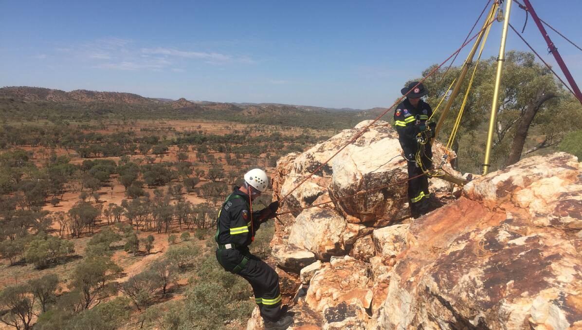 DANGEROUS WORK: Firefighter Reece McClelland descends Razorback Ridge by rope while Lisa Boucher controls the operation at the top.
